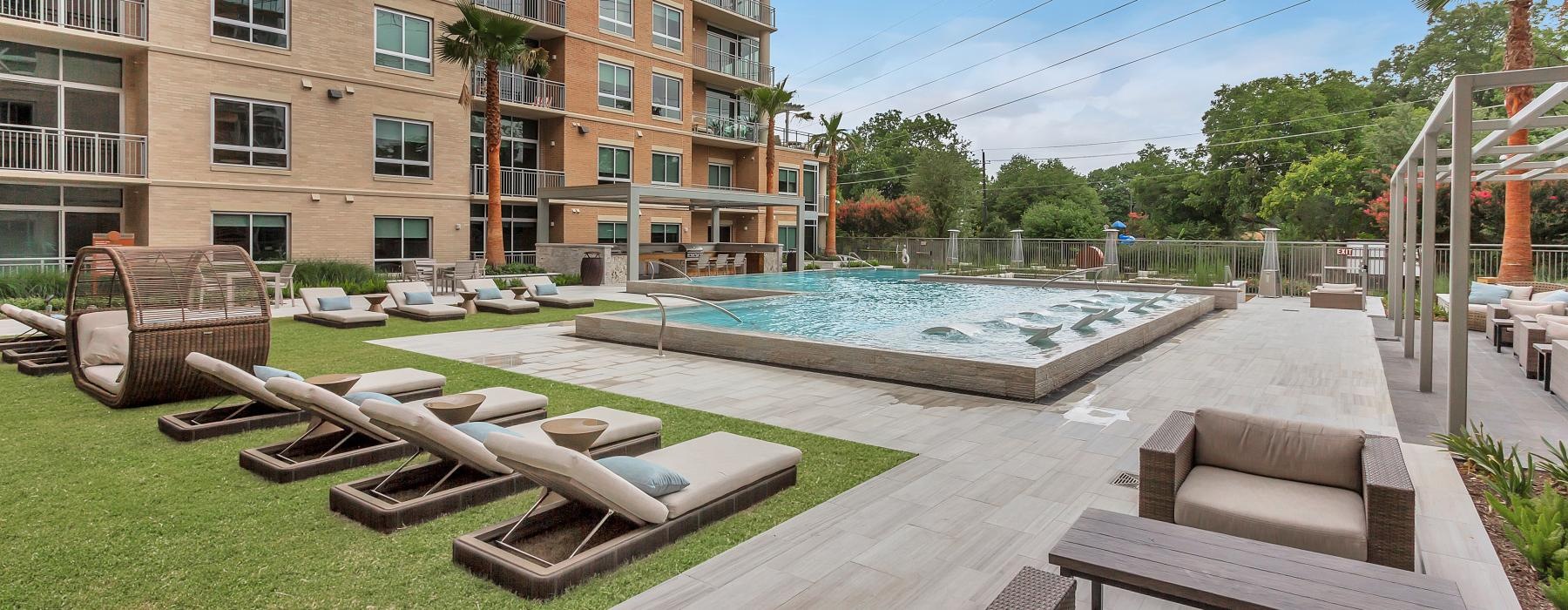 a pool and lounge chairs outside a building