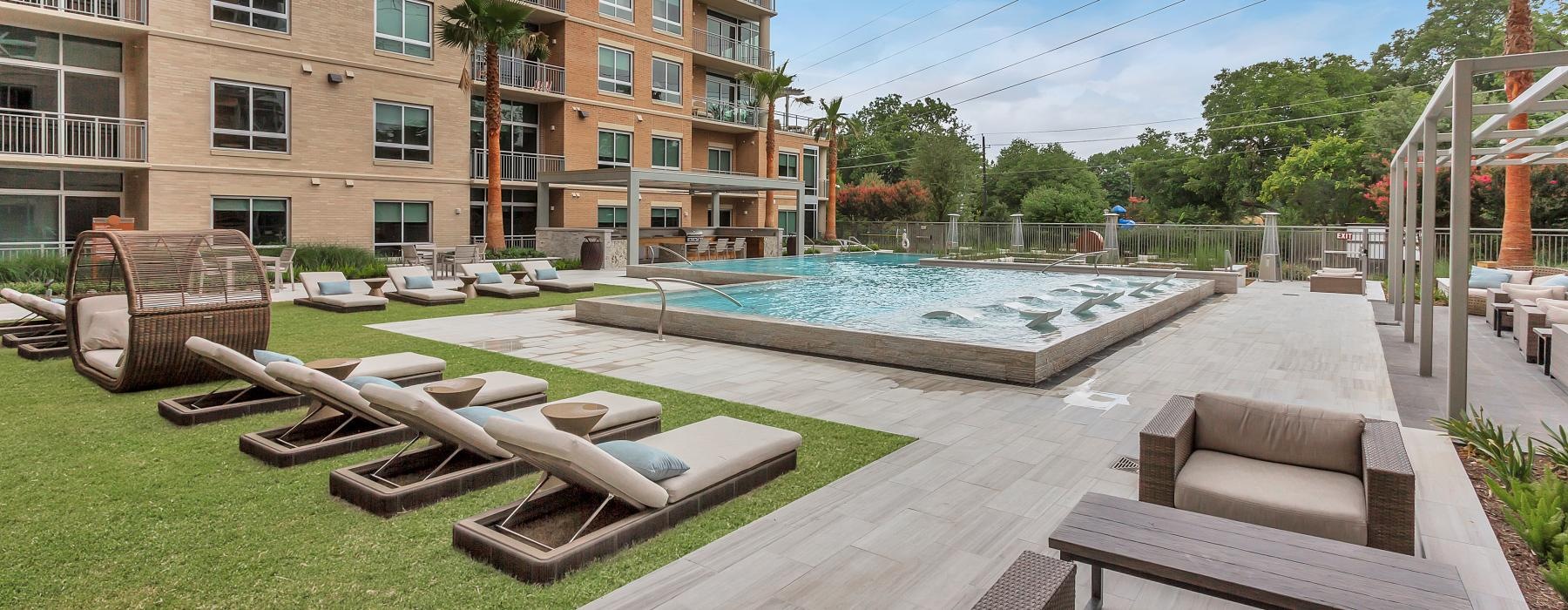 a pool and lounge chairs outside a building